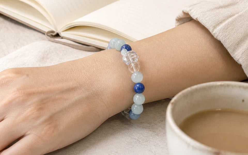 Calm Ritual Bracelet worn at the wrist beside tea and an open notebook