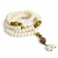 Ivory and green bead mala with a carved brown focal piece