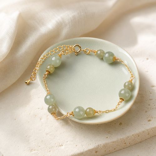 Pale green bracelet arranged on a ceramic dish